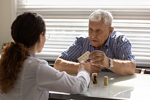 a elderly man talking to his doctor about his supplements 