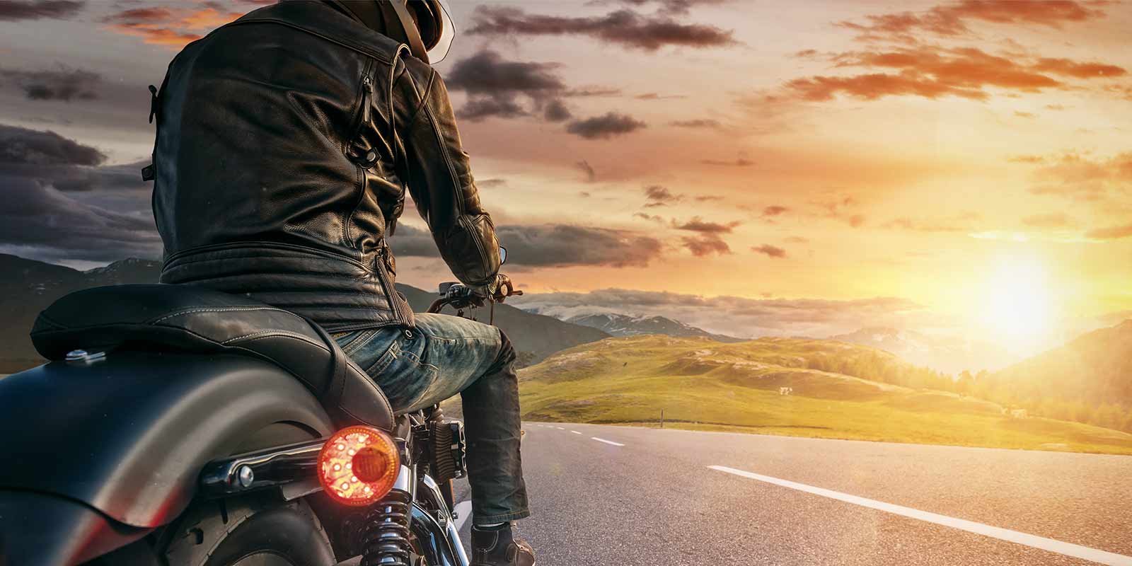 a man riding a motorcycle during sunset