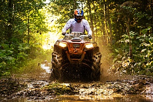 a man riding an atv through the woods