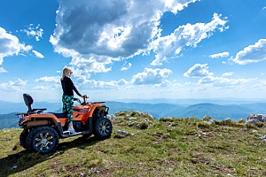 a women riding an atv to the top of the hill 