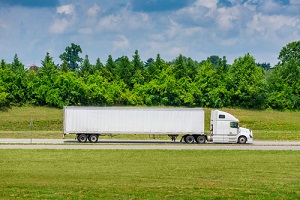 horizontal side view shot of a white tractor trailer with a blank trailer that would make great copy space
