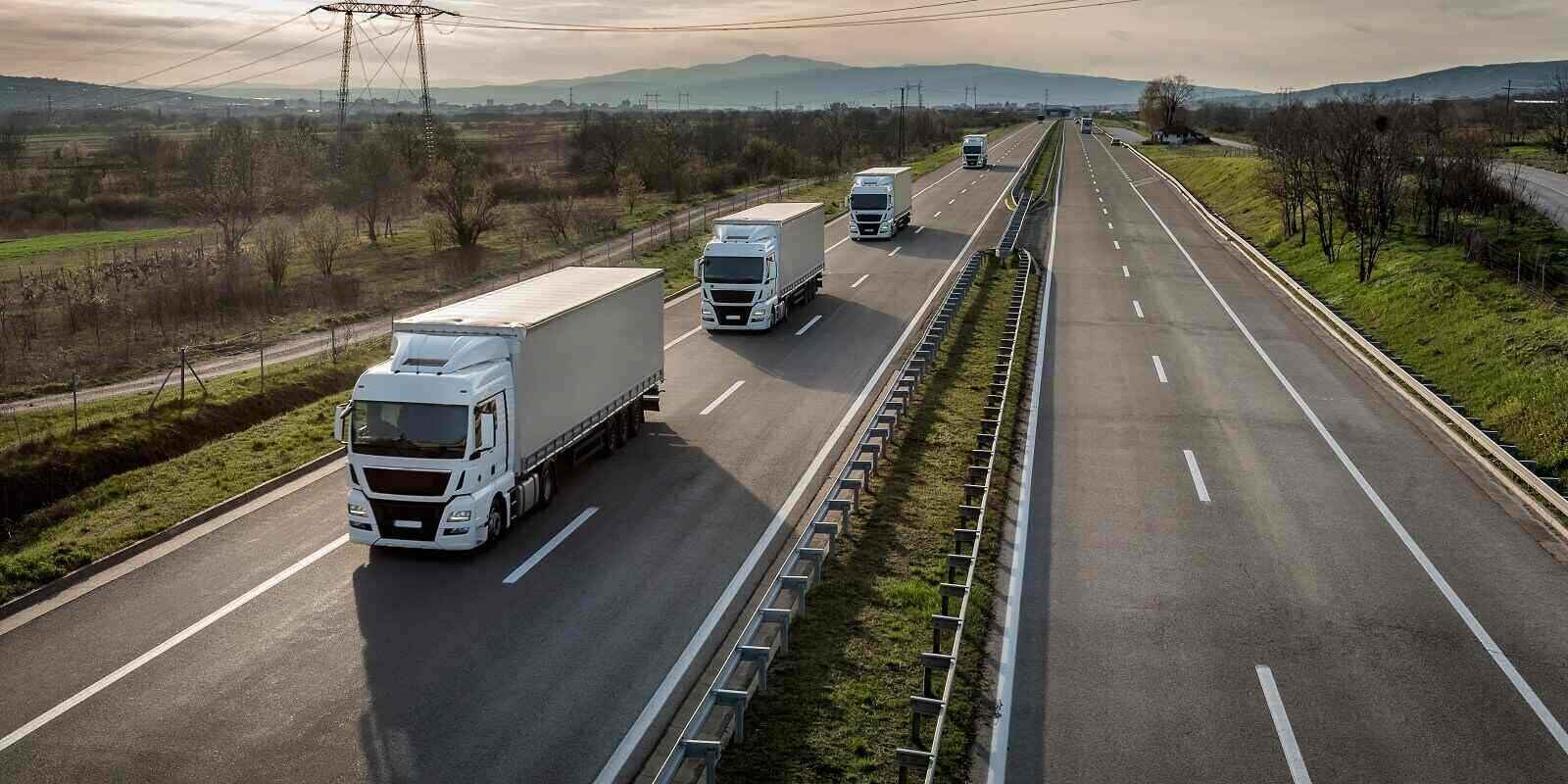 caravan or convoy of trucks in line on a country highway