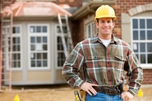 home contractor posing outside property
