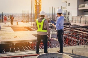 structural engineer and foreman worker with touch pad discuss
