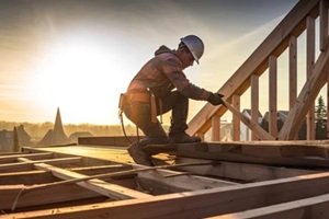 roof worker or carpenter building a wood structure house construction