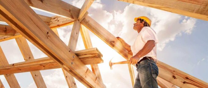 roofer builder working on roog structure of building on construction site