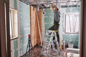 young builder makes a plasterboard ceiling