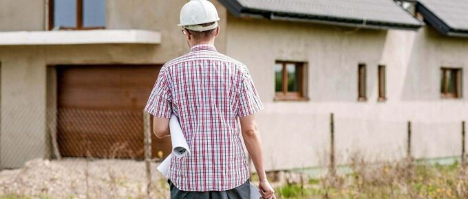 home builder outside a home with construction map