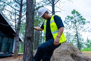 construction worker inspecting building site in forest environment