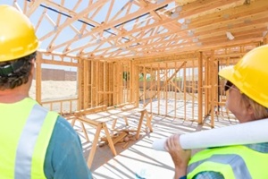 male and female contractors overlooking new house framing at constrcution site
