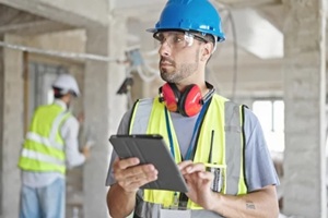 two men builders using touchpad at construction site